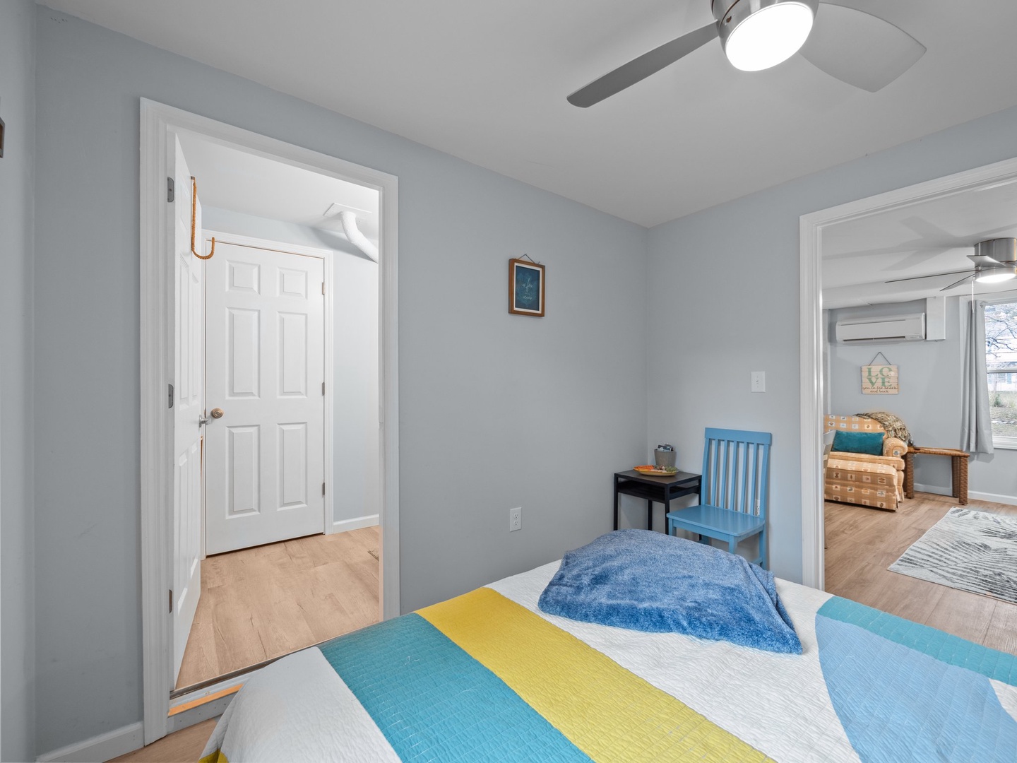 Rest peacefully in this bright bedroom with coastal colors and gentle ceiling fan keeping you cool.