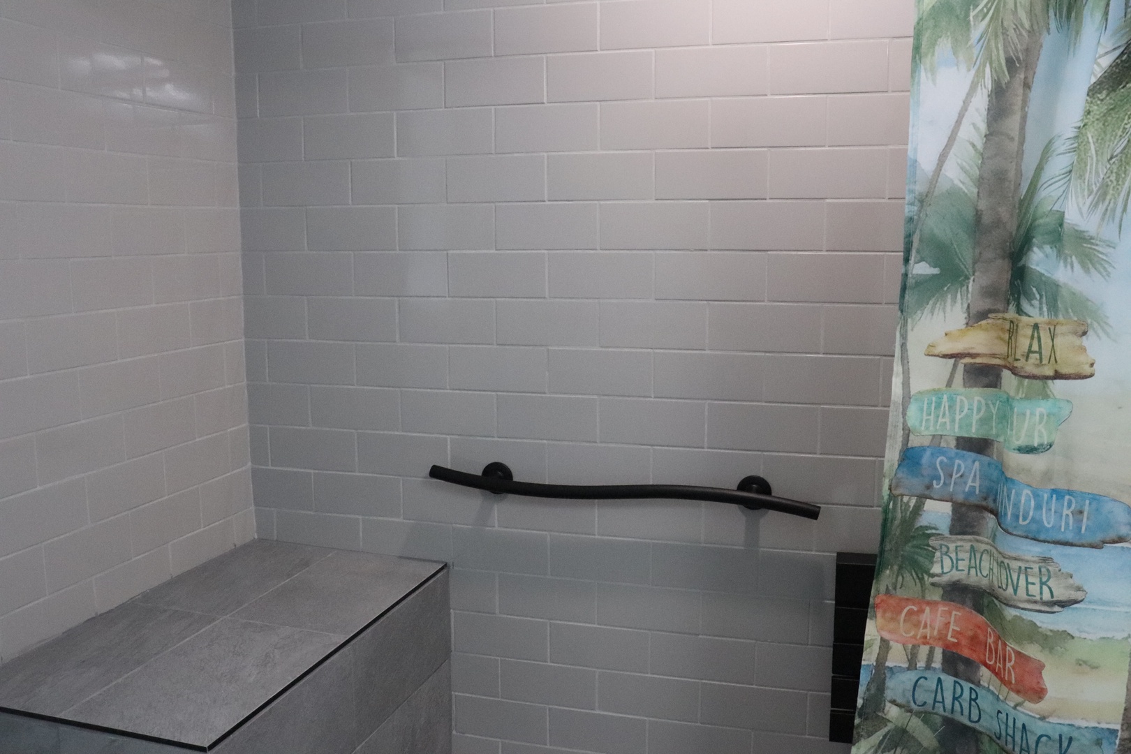 Step into a spotless, modern shower retreat where clean white subway tiles and a tropical touch set a calming, beachy vibe for your daily refresh.