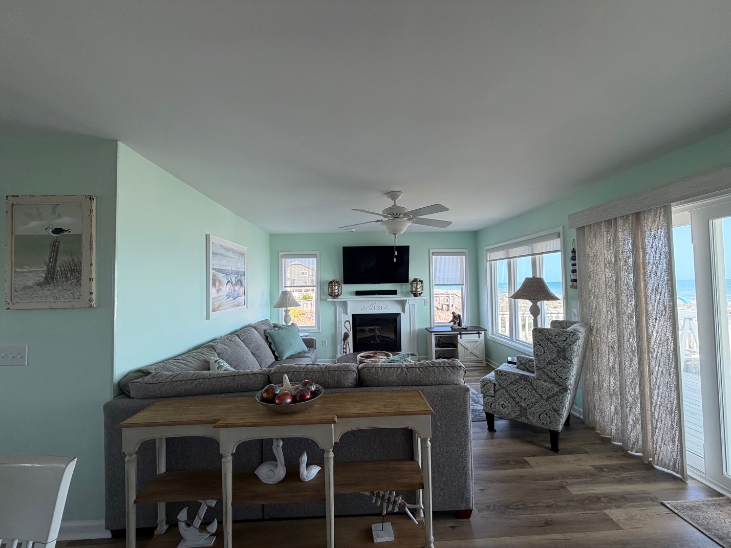 Relax in your bright living room with cozy sectional seating, fireplace warmth, and stunning views through floor-to-ceiling windows.