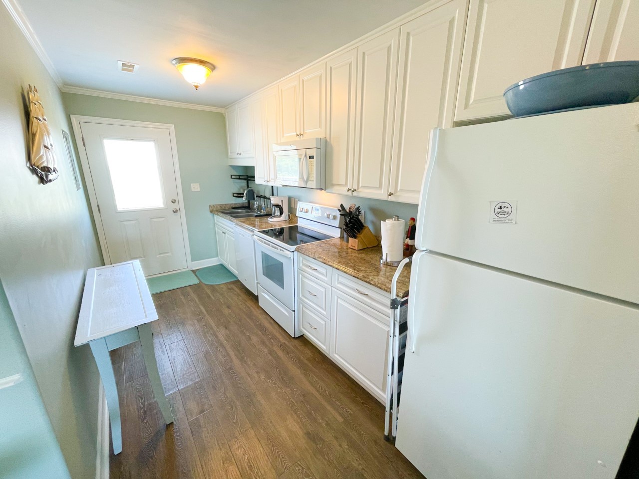 Your fully equipped kitchen features crisp white cabinets, granite countertops, and modern appliances ready for your culinary adventures.