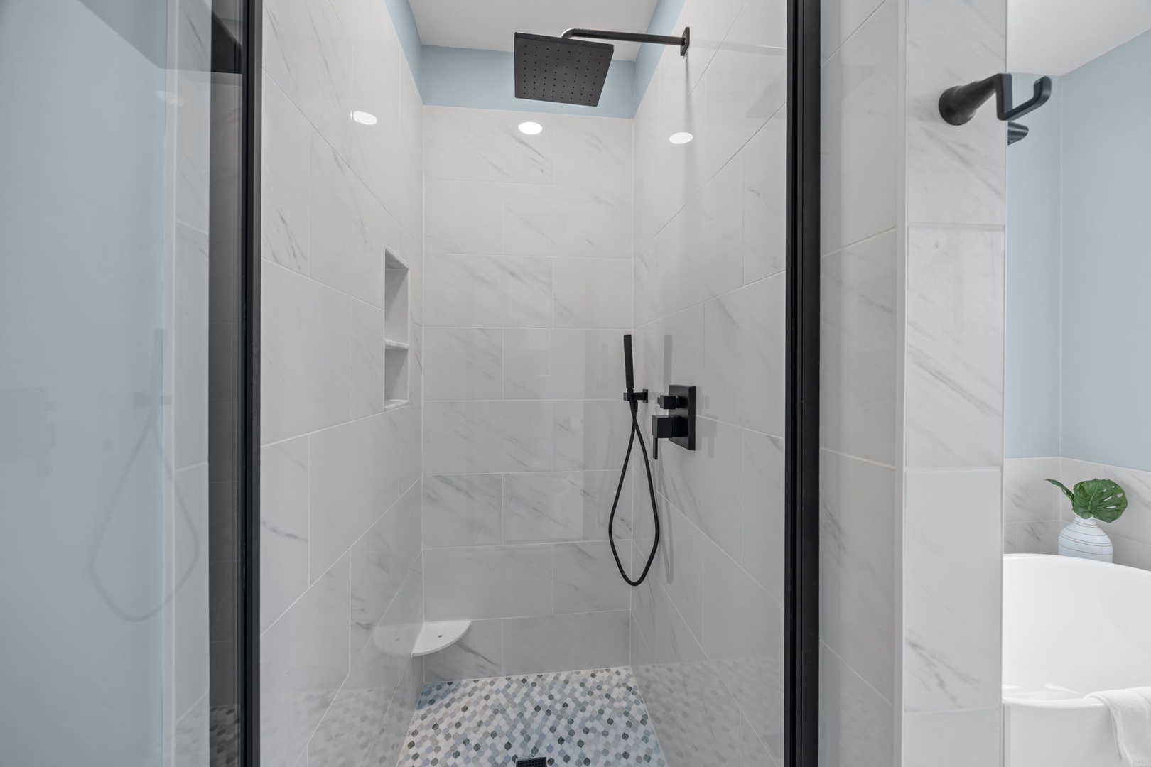 Step into your luxurious marble shower with rainfall head and modern fixtures for a refreshing start to your day.