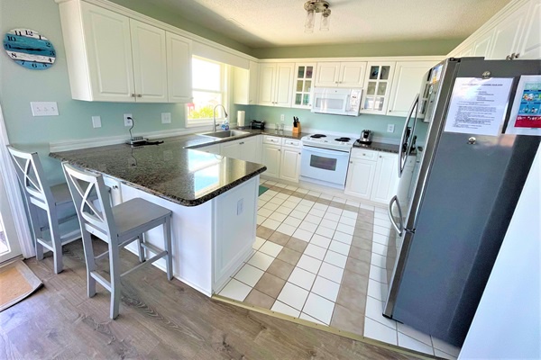 Your spacious kitchen features granite countertops, white cabinetry, and modern appliances where you can prepare memorable meals with loved ones.