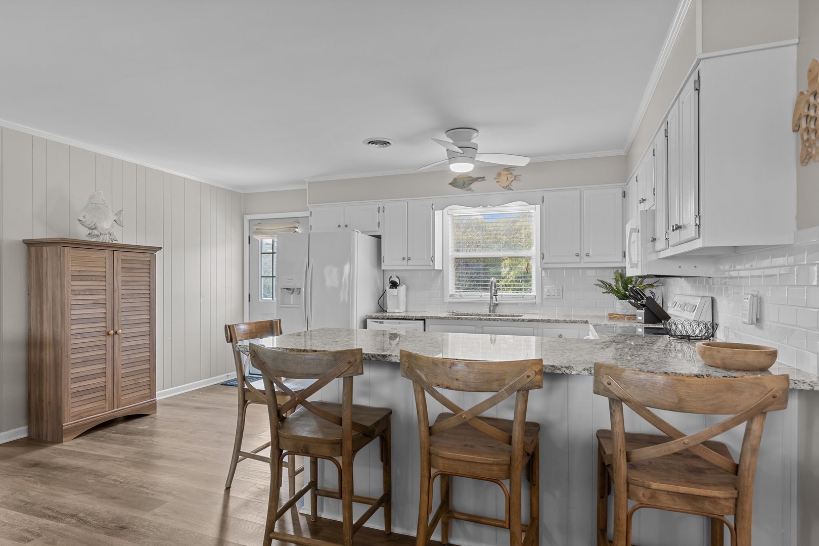 Your fully equipped kitchen features granite counters, modern appliances, and breakfast bar seating perfect for morning coffee and meal prep.