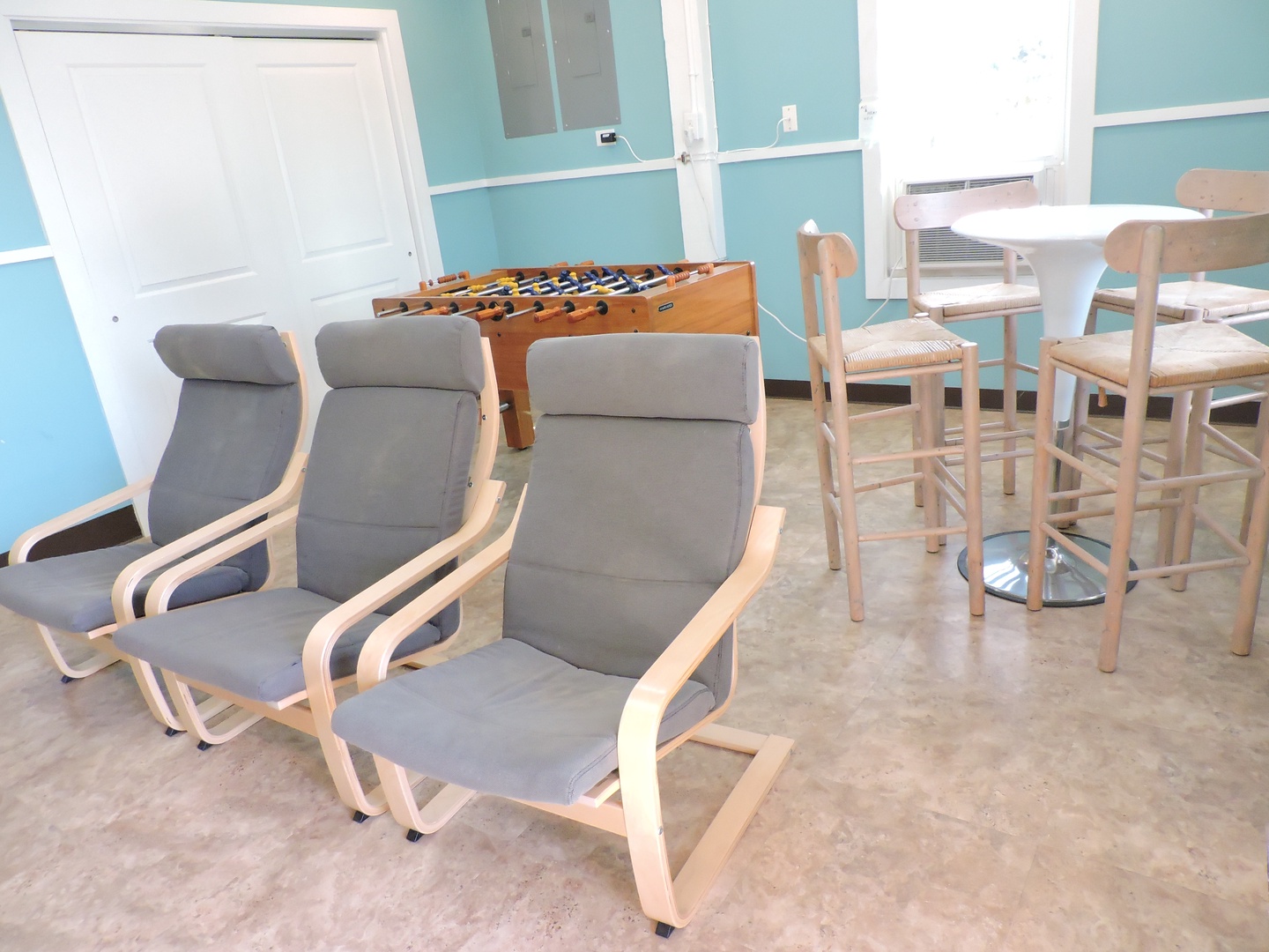 Unwind in your entertainment room with comfy seating, foosball fun, and a bright dining nook for games and gatherings.