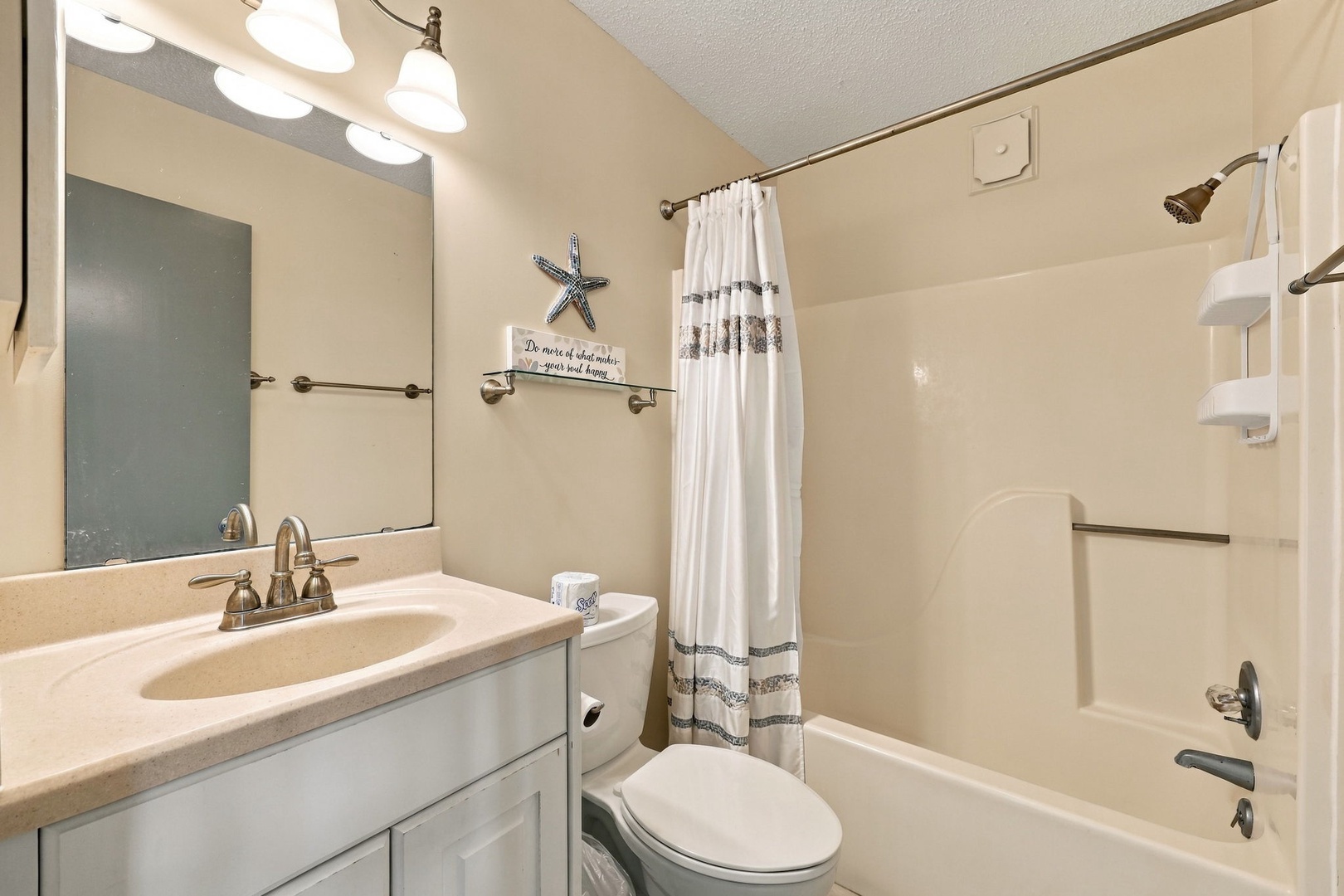 A welcoming bathroom awaits you with a tub-shower combo, generous vanity space, and coastal-inspired decor. Bright lighting and clean lines make freshening up easy and comfortable.