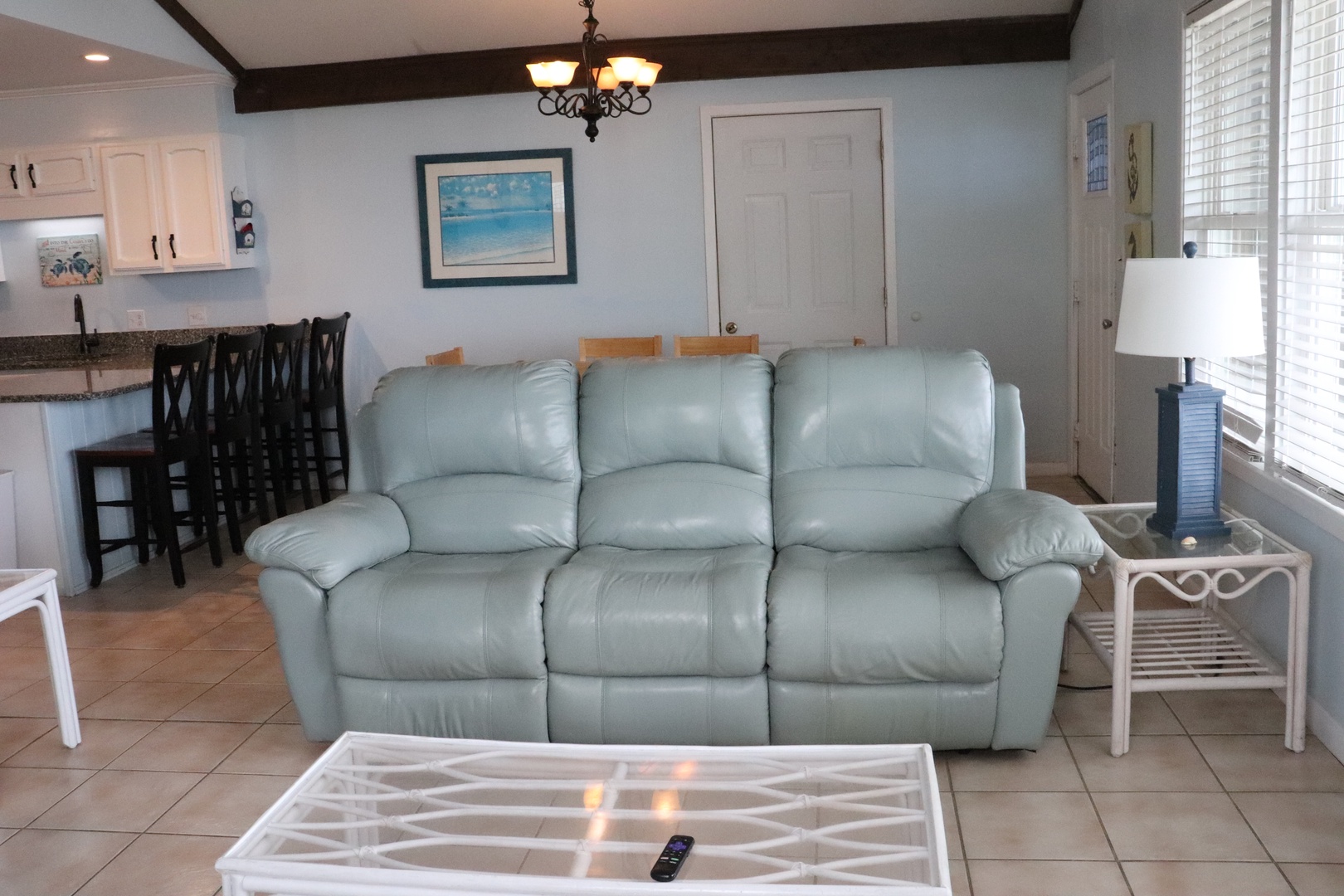 Sink into the plush sofa in your open-concept living space, where coastal charm meets comfort. Light-filled rooms, beachy artwork, and thoughtful touches invite you to unwind and enjoy your getaway.