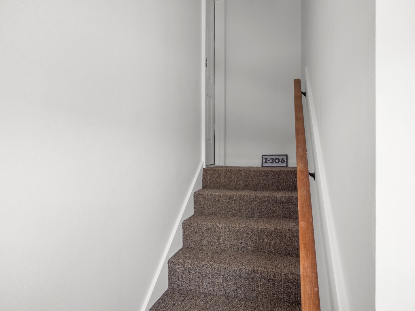 Climb the carpeted stairs to your private retreat in unit 1306, where comfort awaits beyond the landing.