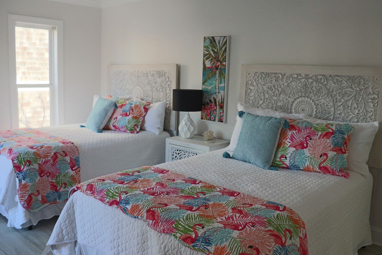 Drift off in your bright tropical haven, where twin beds showcase vibrant island-inspired linens and intricate carved headboards create vacation magic.