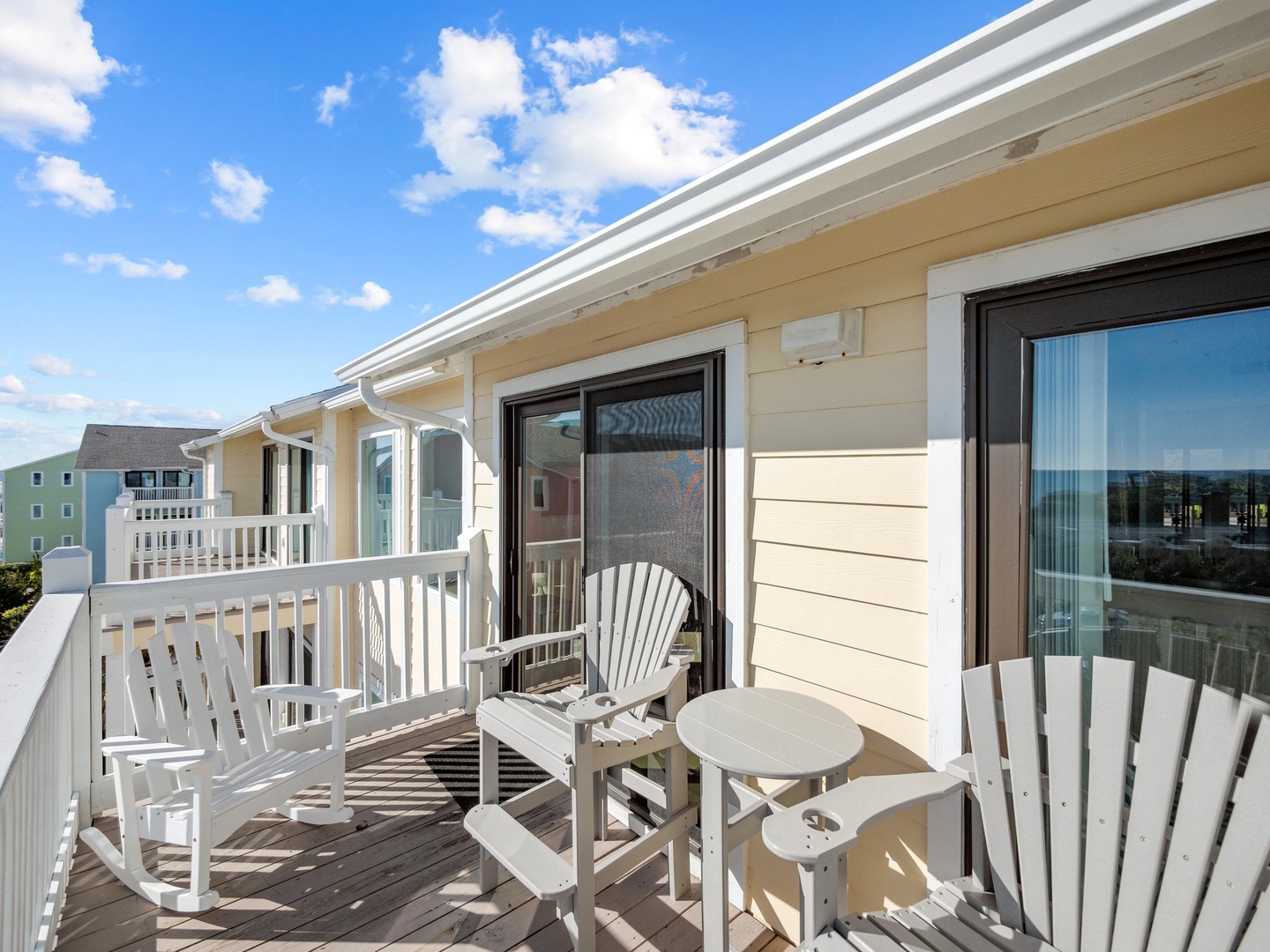 Step onto your private balcony where white Adirondack chairs invite you to unwind while taking in the coastal breeze and peaceful surroundings.