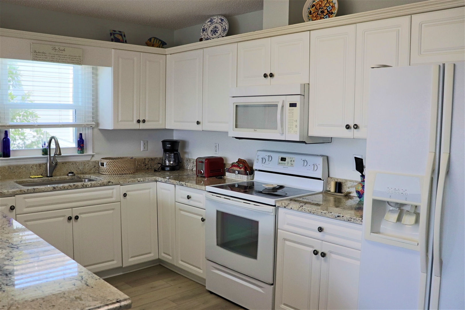Your fully equipped kitchen awaits with granite countertops, white appliances, and everything you need to create memorable meals during your stay.
