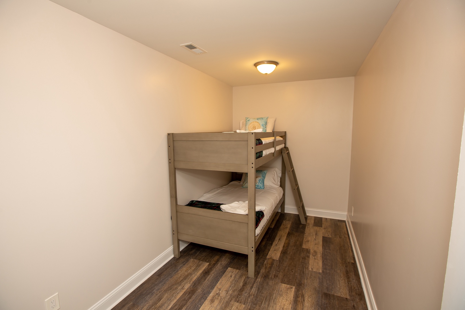 Your kids will love this cozy bunk bed room with warm wood floors and soft lighting for peaceful nights.