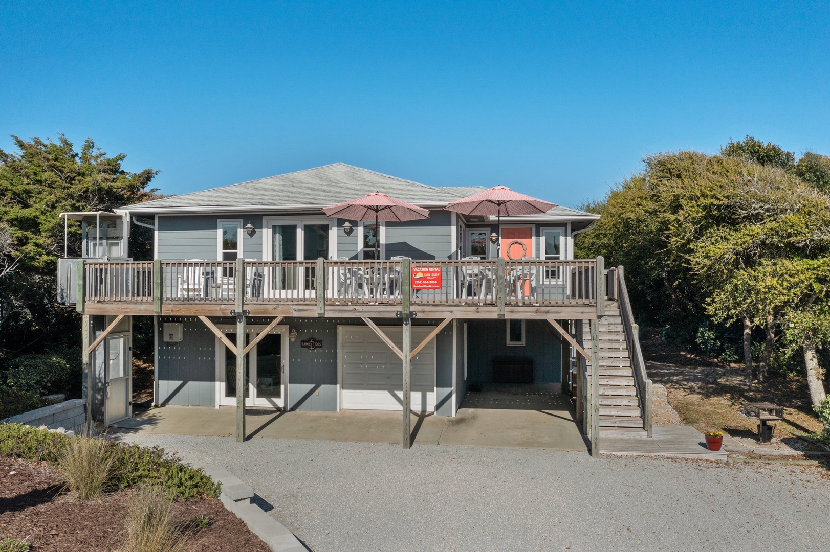 Elevated beach house with spacious deck, outdoor dining, and natural coastal surroundings for a perfect getaway.