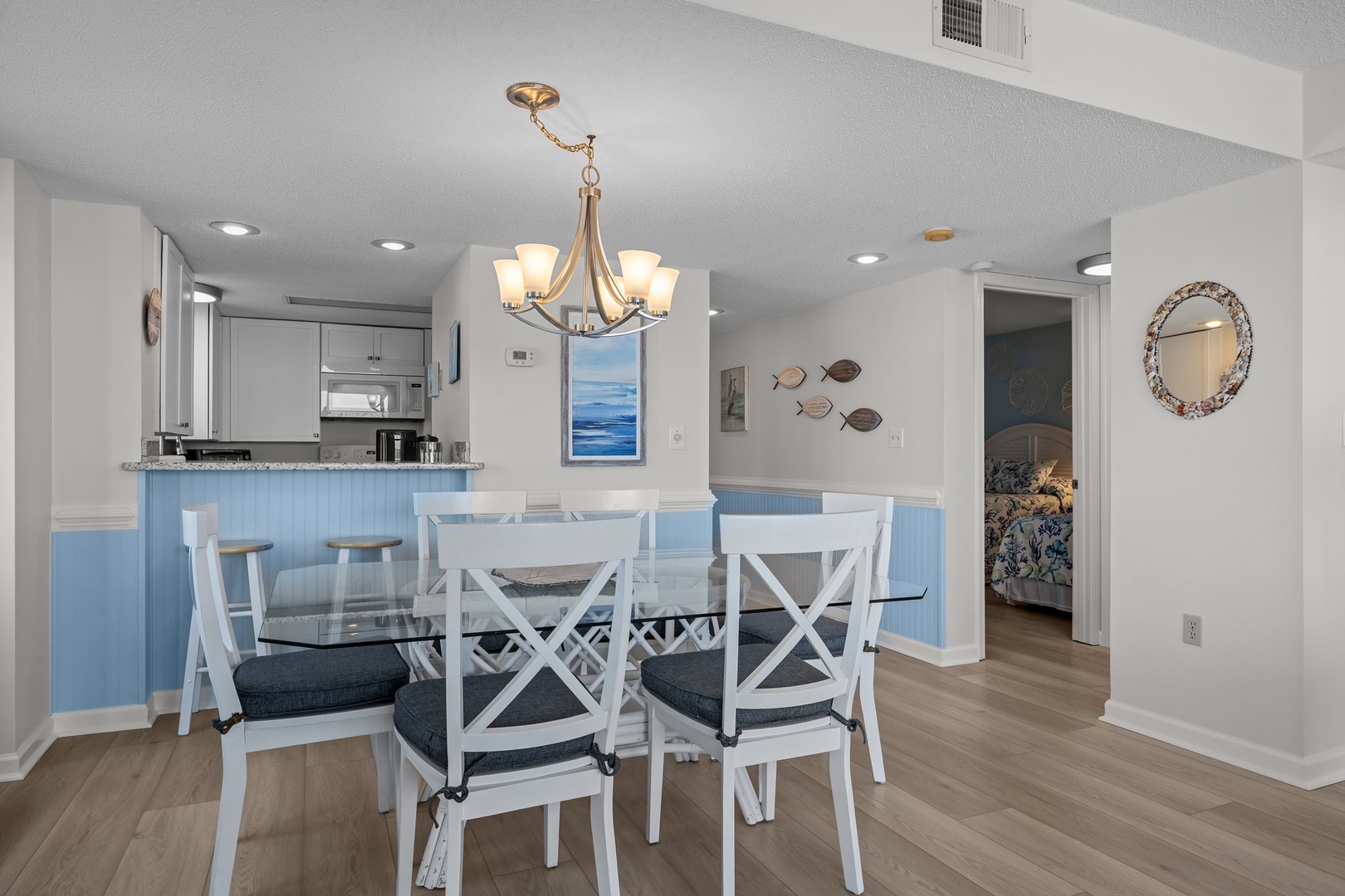 Gather around your elegant dining table while the kitchen beckons with coastal charm and ocean-inspired décor.