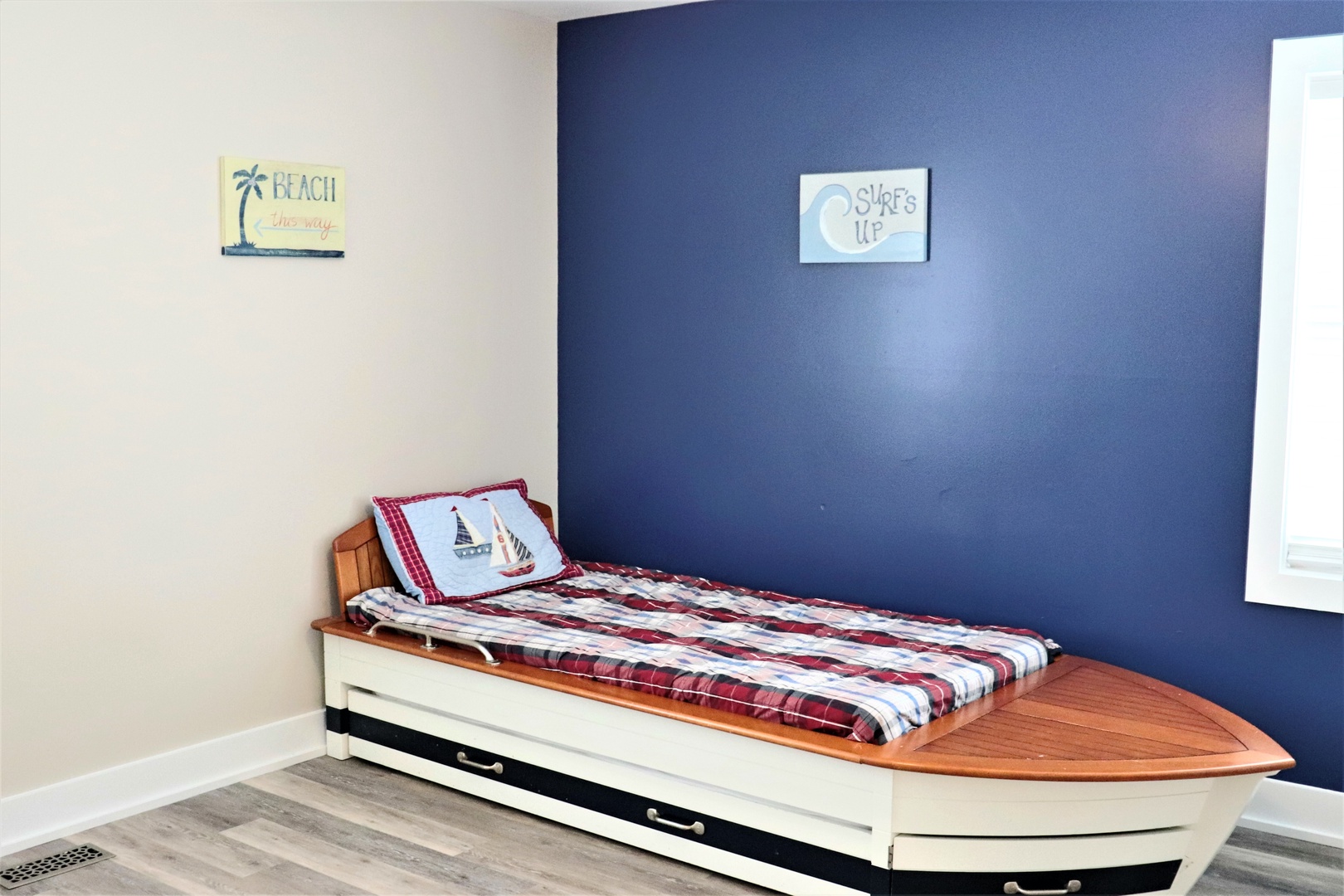 Dream away in this charming boat-shaped bed with nautical touches and cheerful beach decor surrounding you.