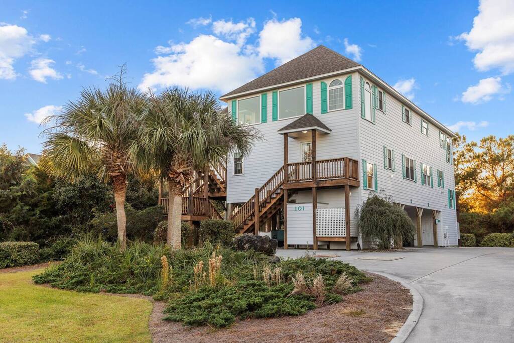 A charming coastal home with tropical landscaping and elevated design, featuring convenient parking and natural surroundings for your beach getaway.