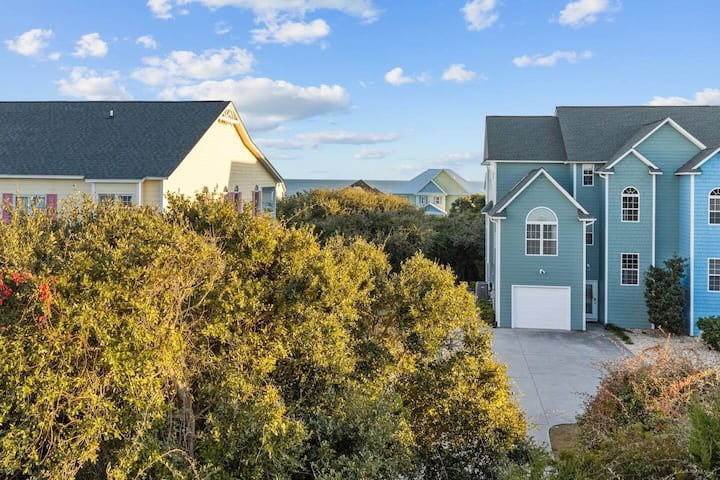 Beautiful coastal neighborhood setting with colorful beach homes and ocean views beyond the dunes.