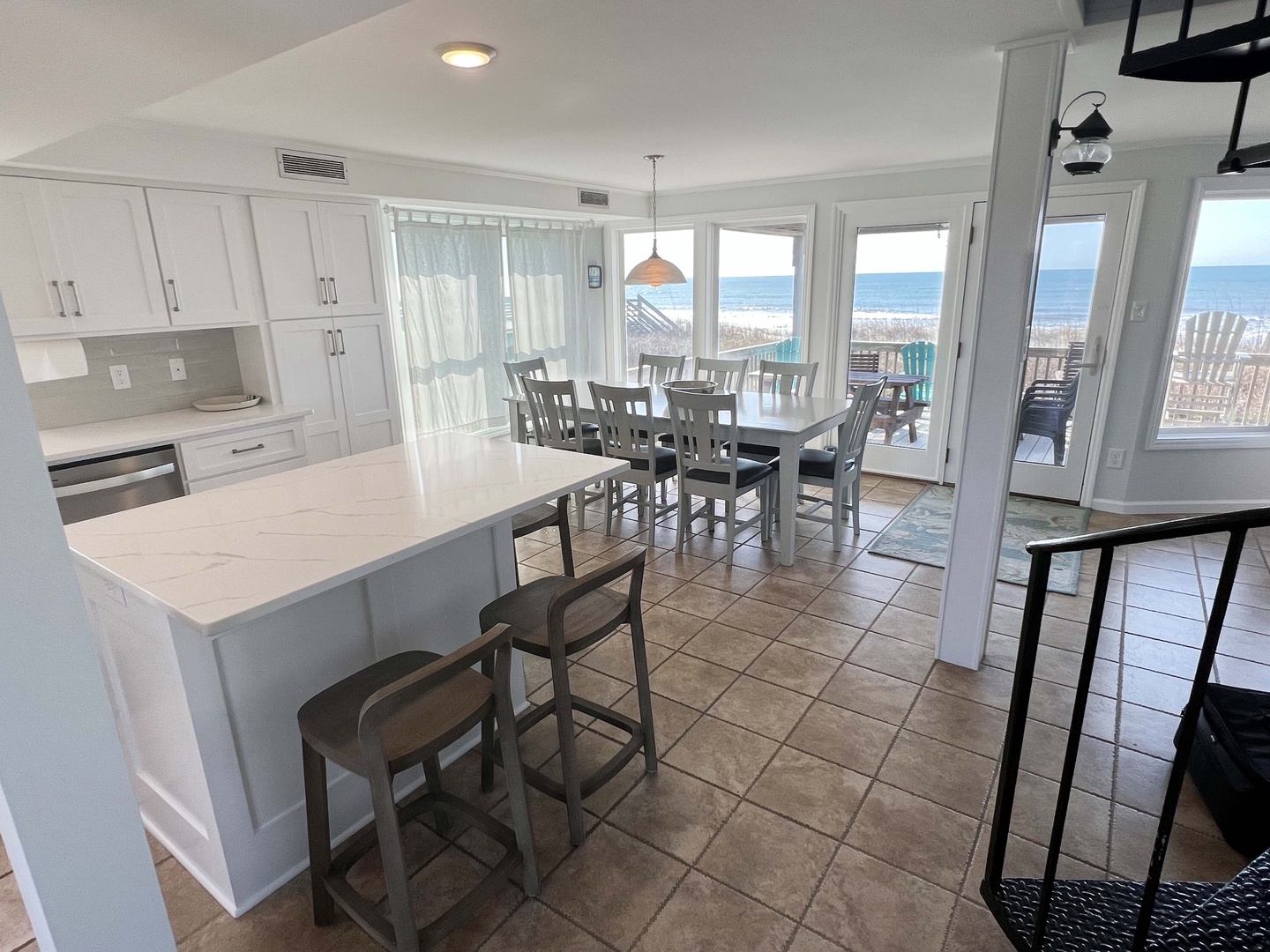 Your bright kitchen flows seamlessly into the dining area, where ocean views frame every meal through expansive windows.