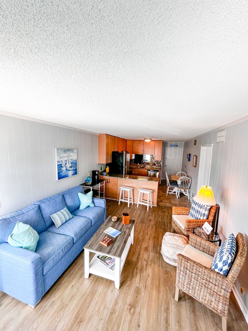 Relax in your bright coastal living space with plush blue sofa and fully-equipped kitchen perfect for preparing meals together.