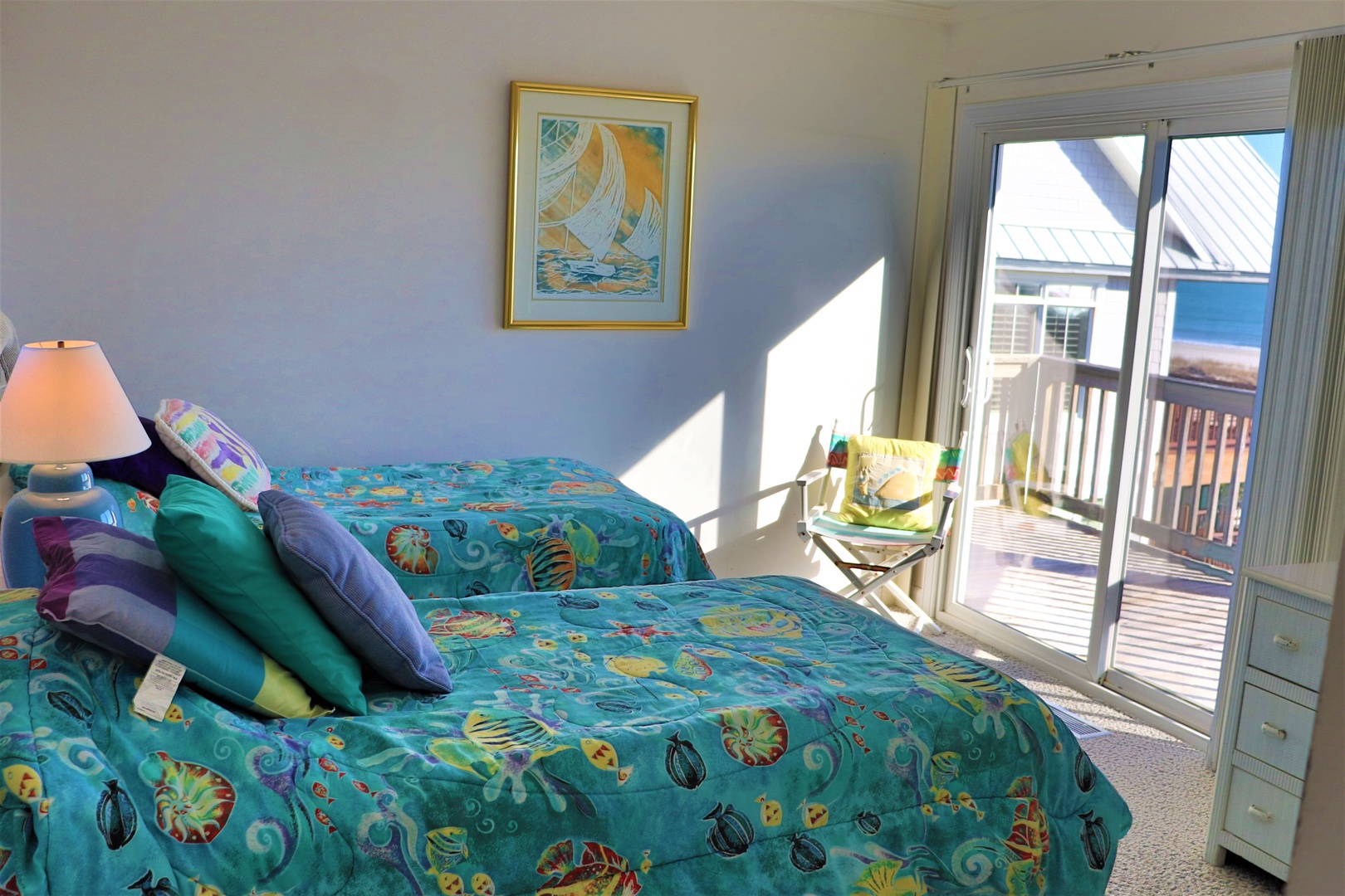 Wake up to ocean breezes in your cheerful bedroom with twin beds and private balcony access overlooking the coastal community.