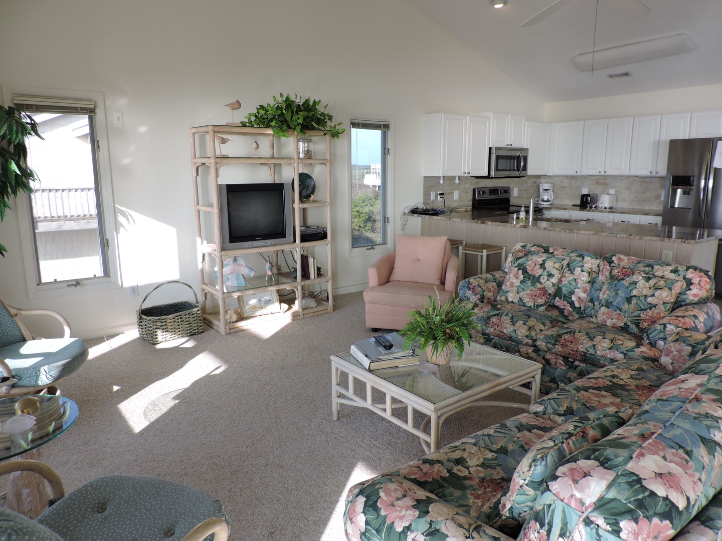 Relax in your bright, airy living space with comfortable seating and fully equipped kitchen. Natural light fills the room through large windows.