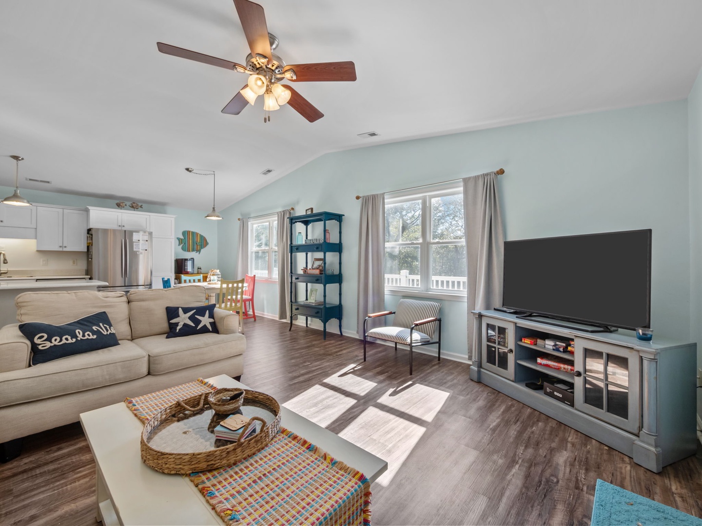 Relax in your coastal-themed living space with comfy seating, large TV, and open kitchen perfect for your beach getaway.