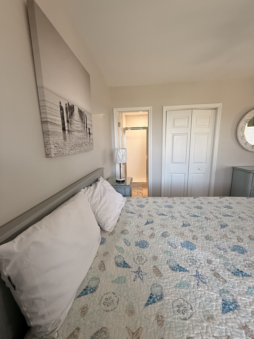 Your coastal-inspired bedroom awaits with a charming seaside quilt and crisp linens. Relax on the cozy platform bed beneath a decorative clock, and enjoy built-in storage that keeps your space serene and uncluttered.