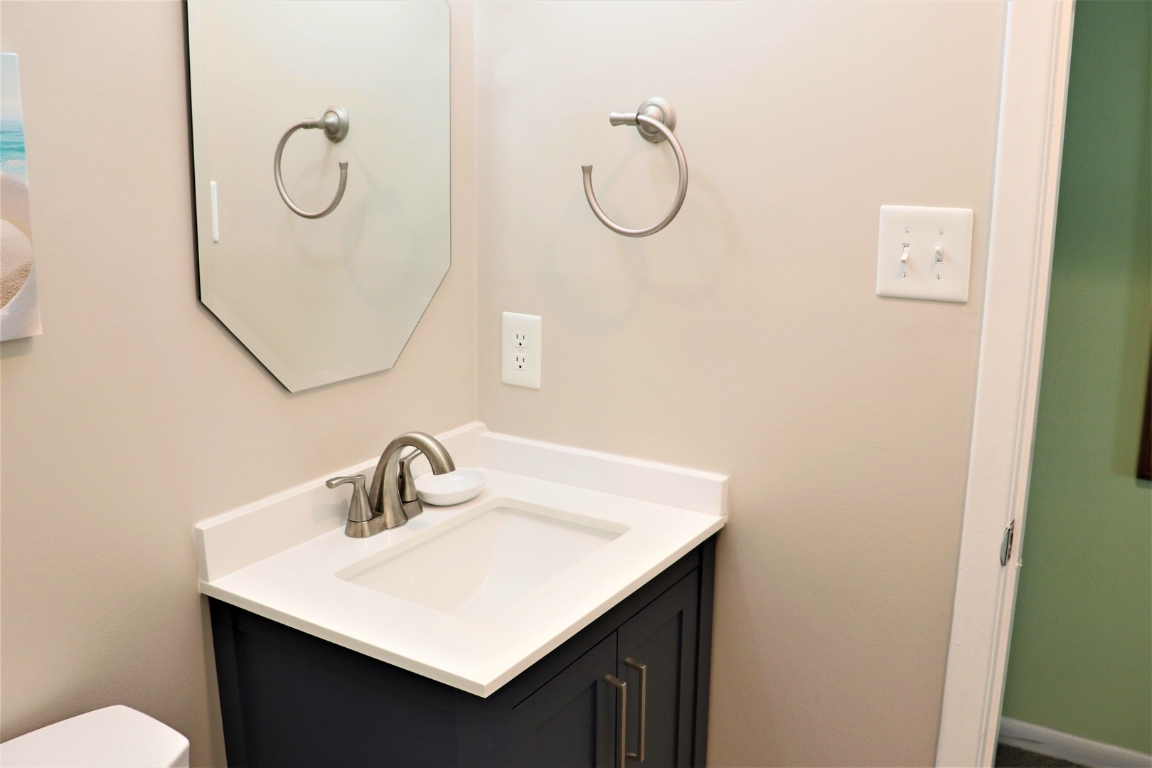 Your sleek bathroom vanity features a pristine white countertop and modern fixtures, creating a fresh space for your morning routine.
