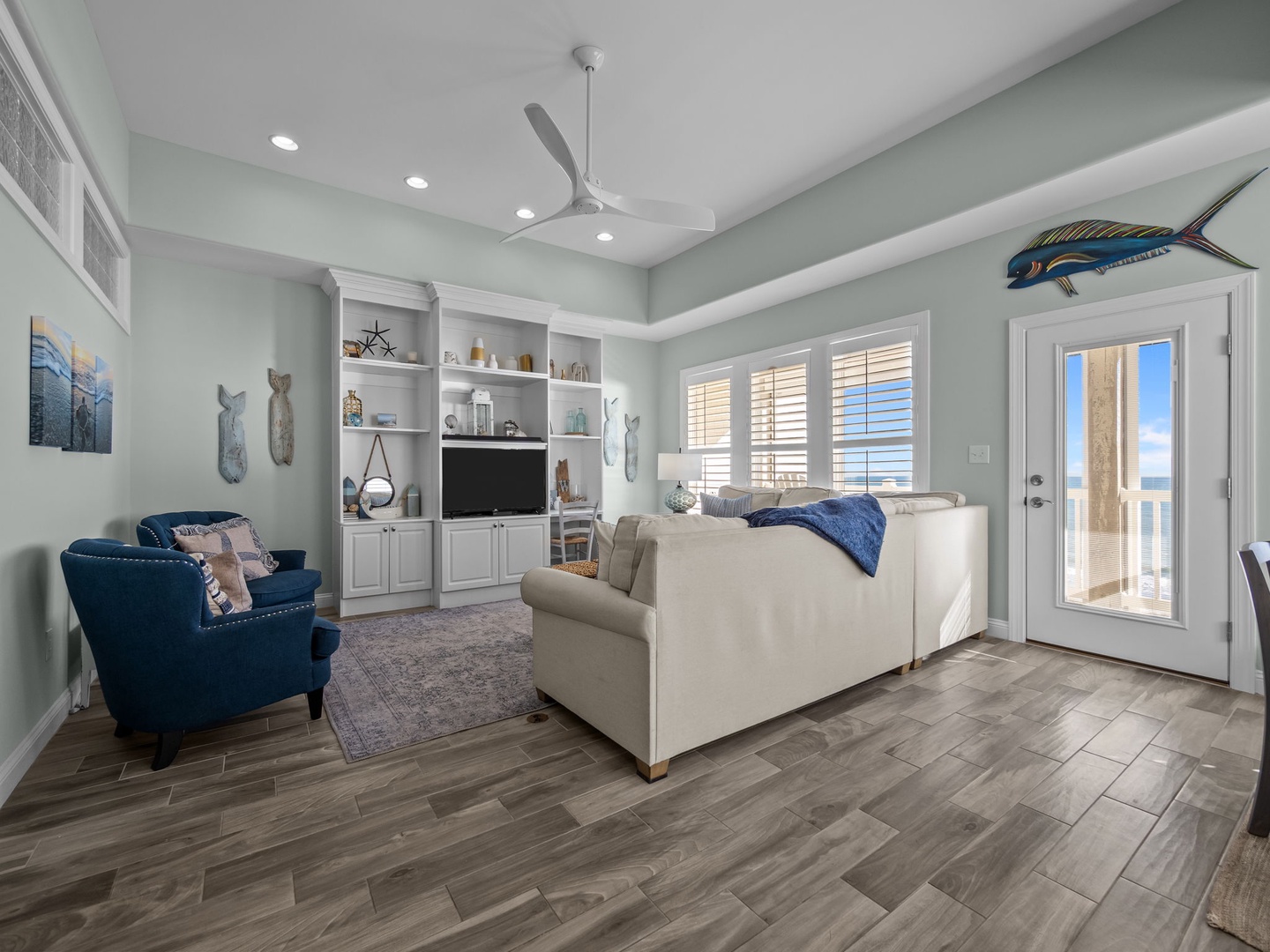 Unwind in this coastal-themed living room where soothing sea-glass walls meet comfortable seating and nautical touches that make you feel right at home.
