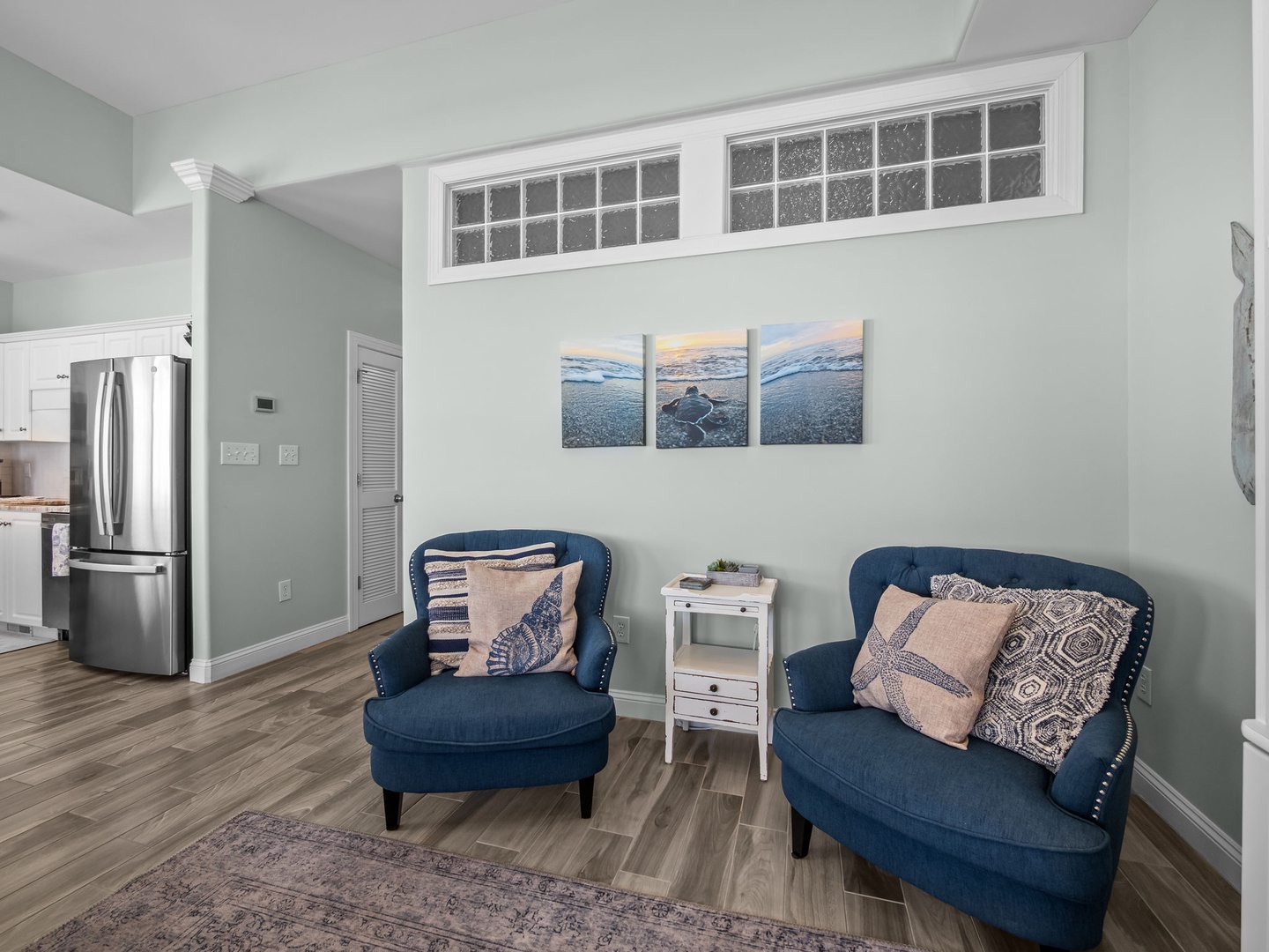 Sink into plush navy armchairs and let coastal artwork transport you to peaceful shores in this calming retreat.