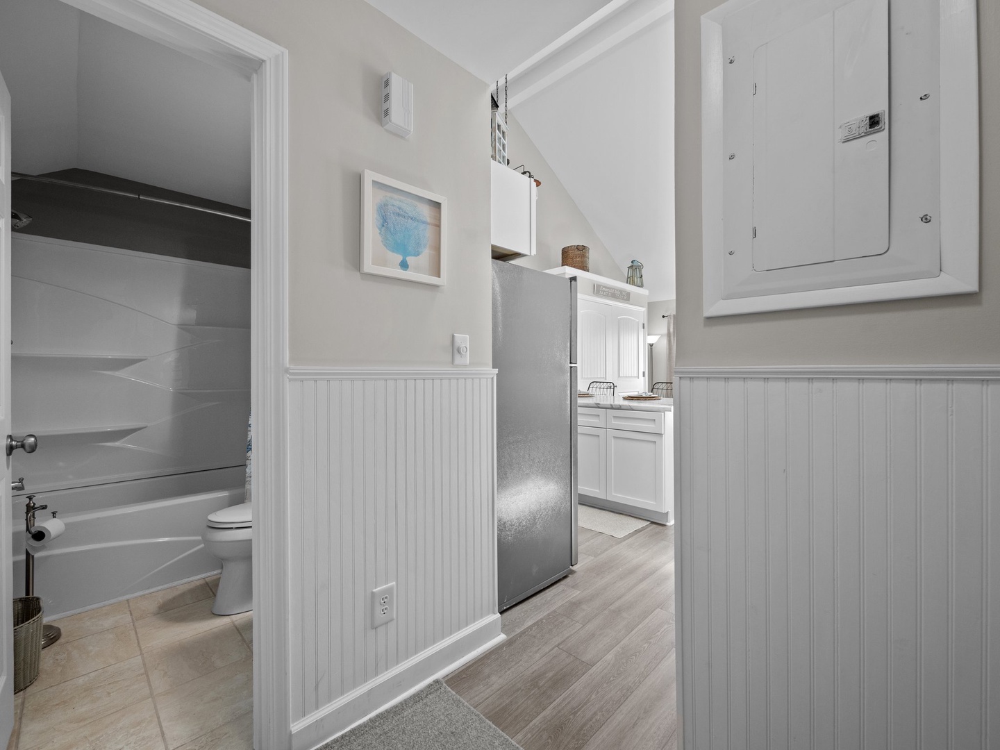You'll love the bright, coastal-inspired hallway connecting your bathroom and kitchen, with charming wainscoting and thoughtful touches throughout.