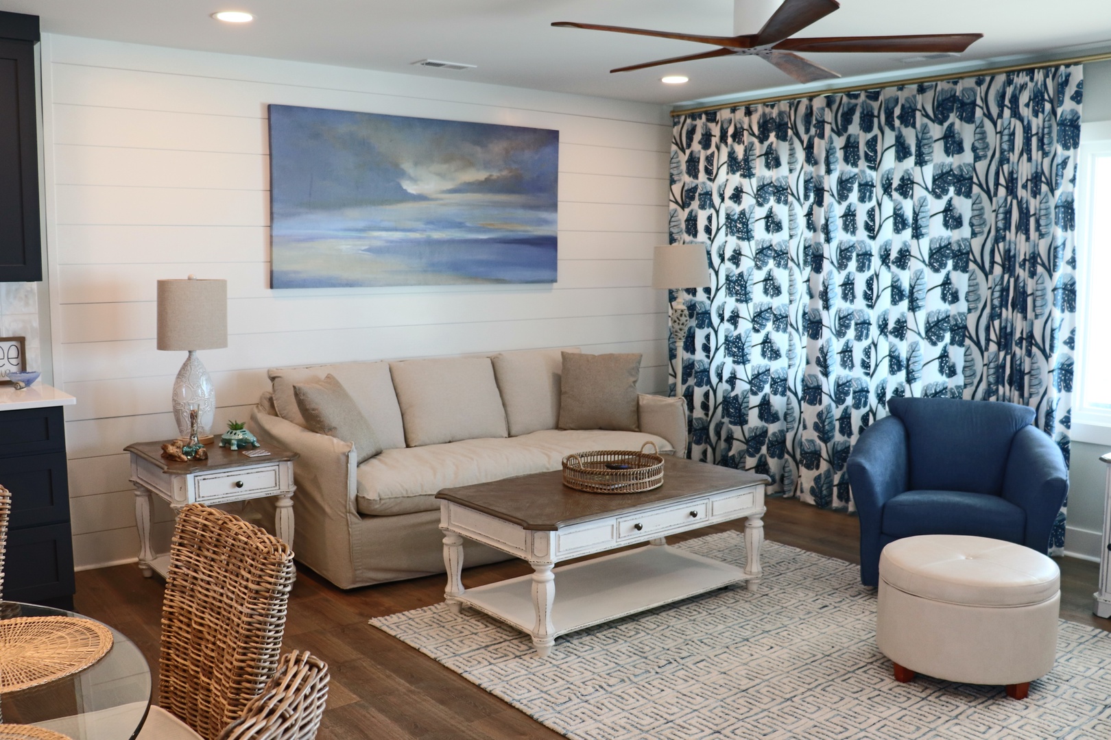 Relax in your coastal-inspired living room with plush seating, elegant artwork, and soothing blues that create the perfect retreat atmosphere.
