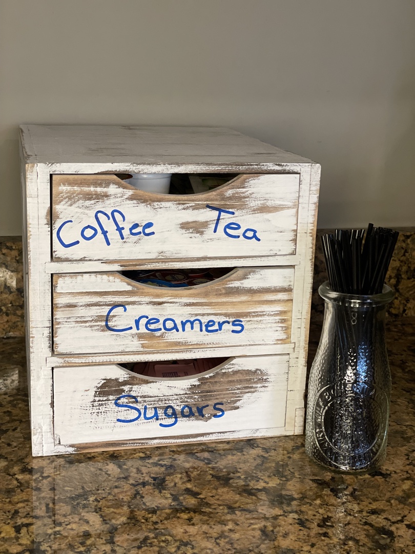 Your morning ritual starts here with coffee, creamers, and sugars neatly organized in rustic charm on granite countertops.