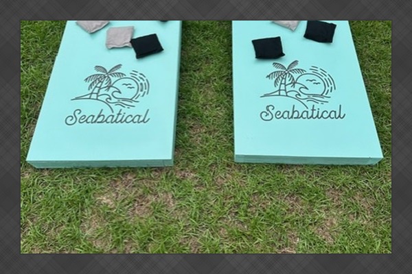 Challenge friends to cornhole with these custom turquoise boards featuring tropical whale designs—perfect for sunny afternoons in your backyard retreat.