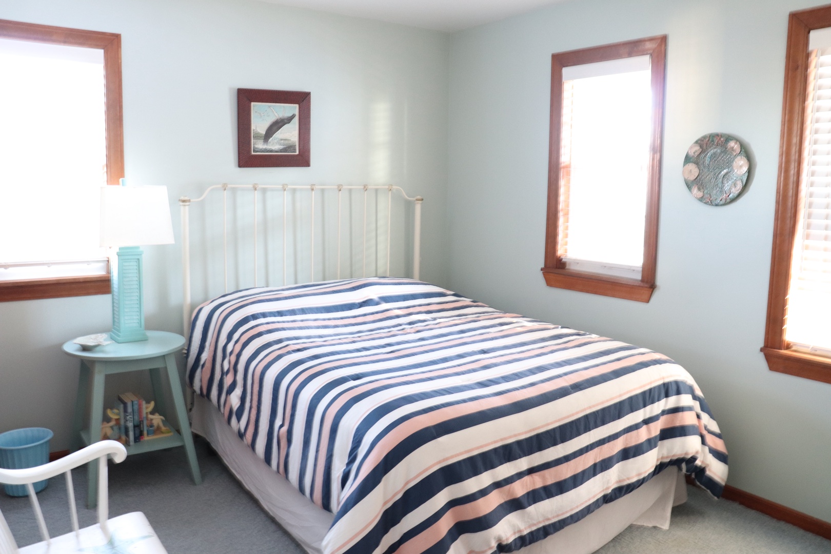 Drift off in this cozy nautical-themed bedroom featuring a comfortable bed and charming coastal decor to make you feel at home.