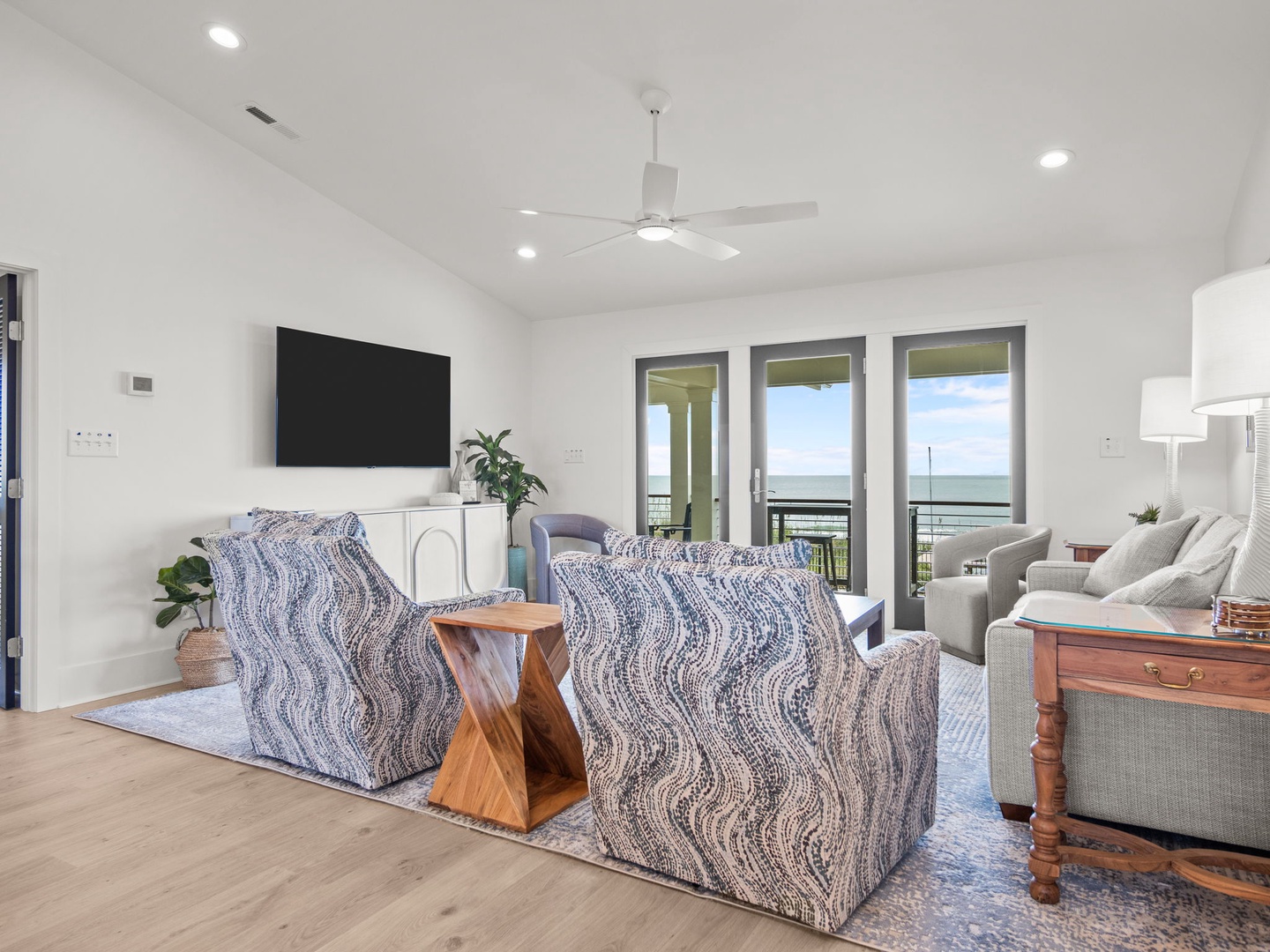 Relax in your stylish living space with ocean views through expansive windows, comfortable seating, and modern amenities.