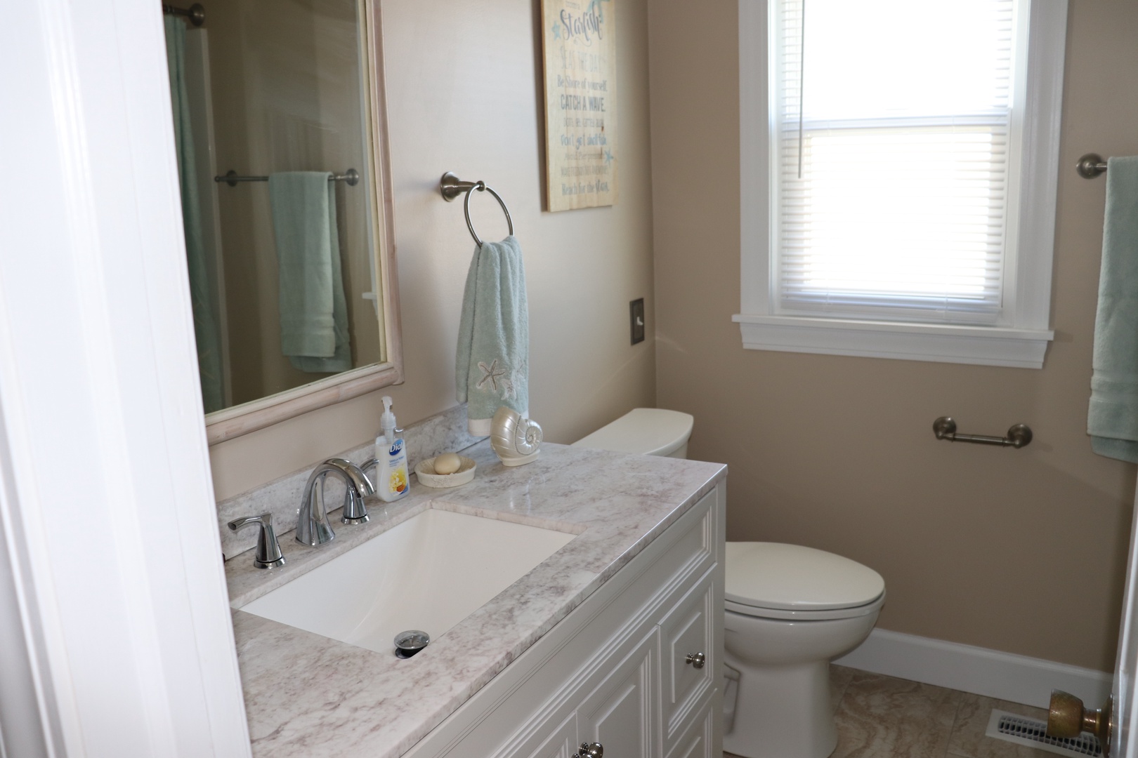 Refresh in your beautifully appointed bathroom featuring marble countertops, soft natural light, and thoughtfully placed amenities for your comfort.