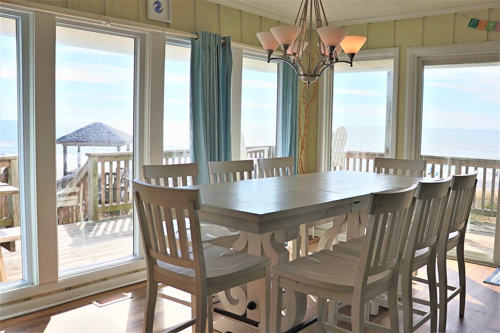 Your spacious dining room offers panoramic ocean views through floor-to-ceiling windows, creating the perfect backdrop for memorable meals with family and friends.