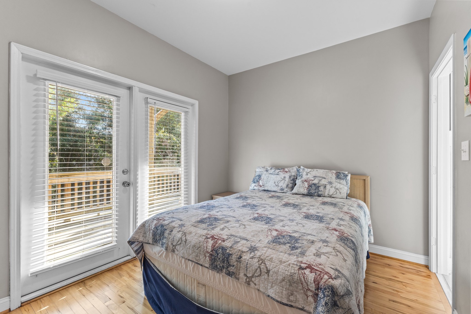 Wake up to natural light streaming through French doors leading to your private outdoor space from this peaceful bedroom.