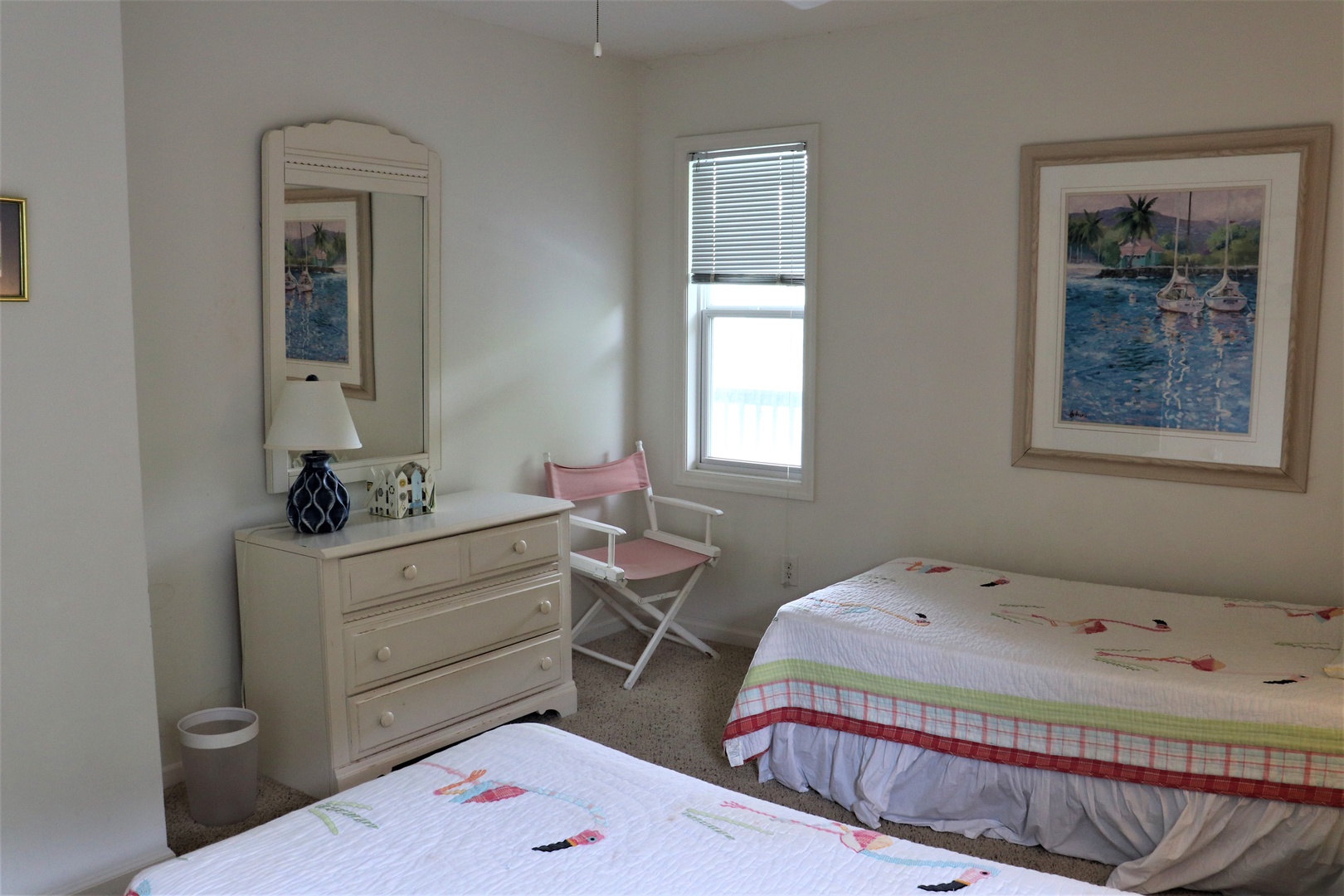 Relax in your bright twin bedroom with nautical artwork and a cozy reading chair by the window.