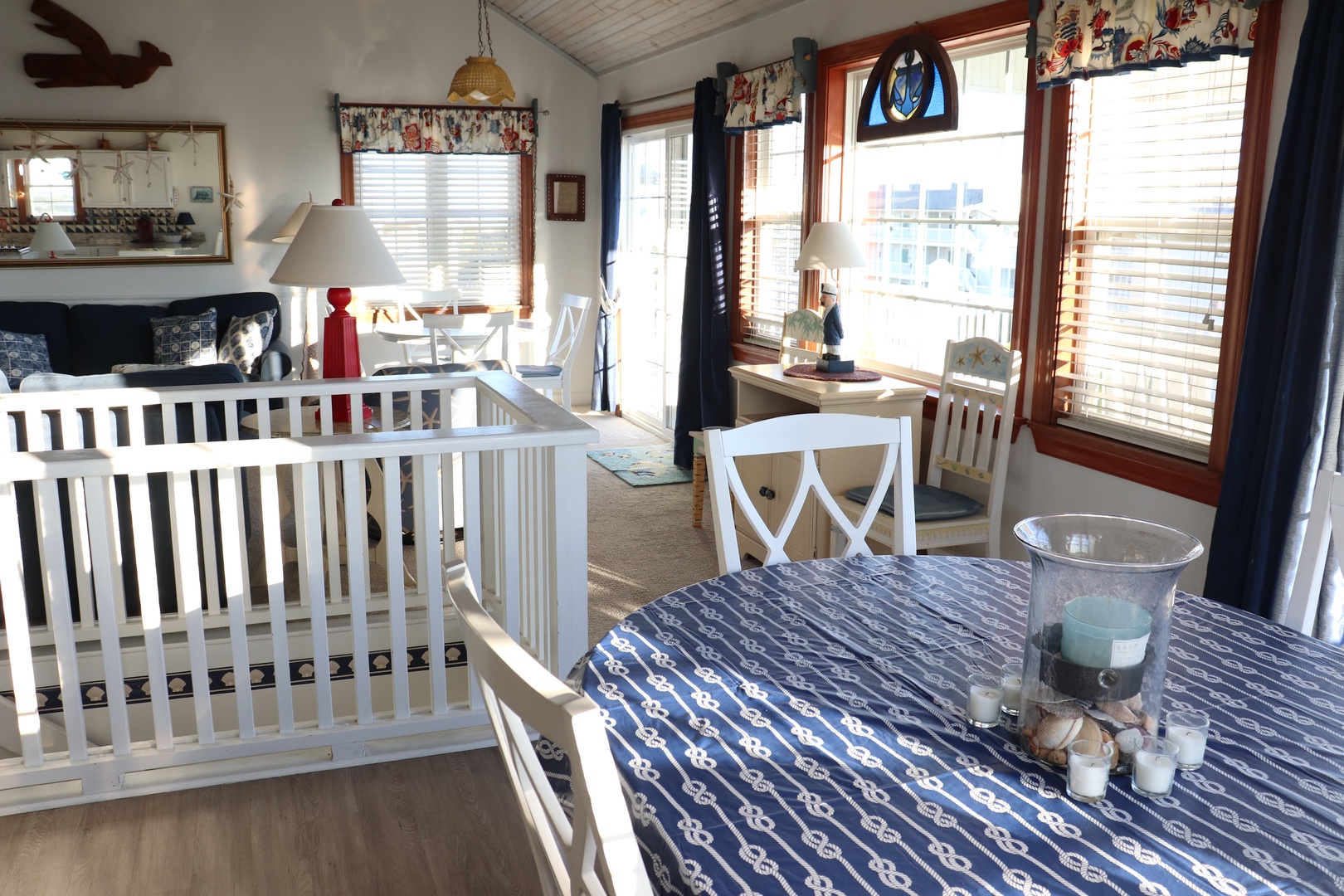 Cozy nautical dining space where you can enjoy meals while your little one rests peacefully in the charming white crib nearby.