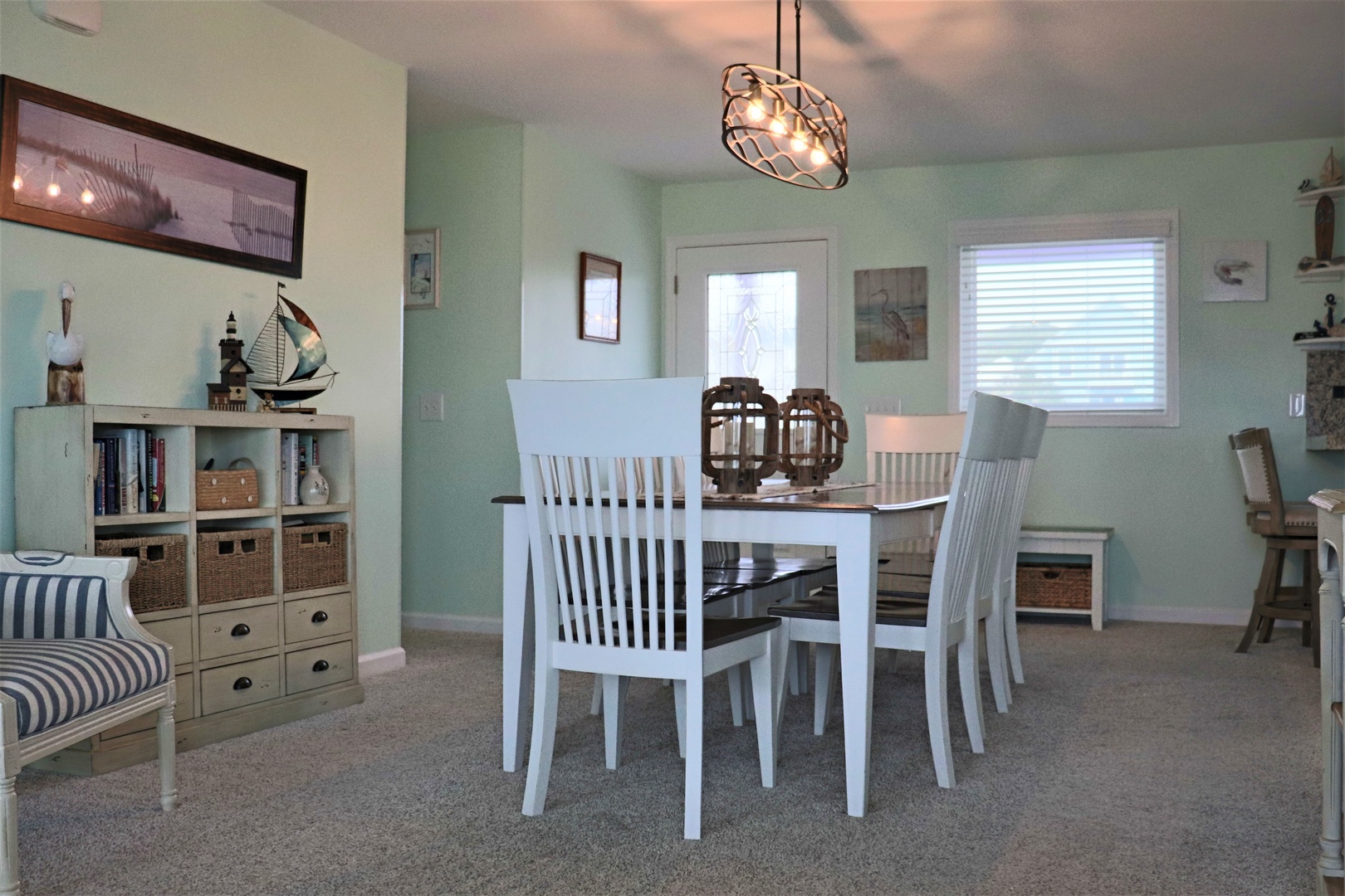 Gather around your elegant dining table in this coastal-themed space, where nautical touches and soft mint walls create the perfect backdrop for memorable meals.
