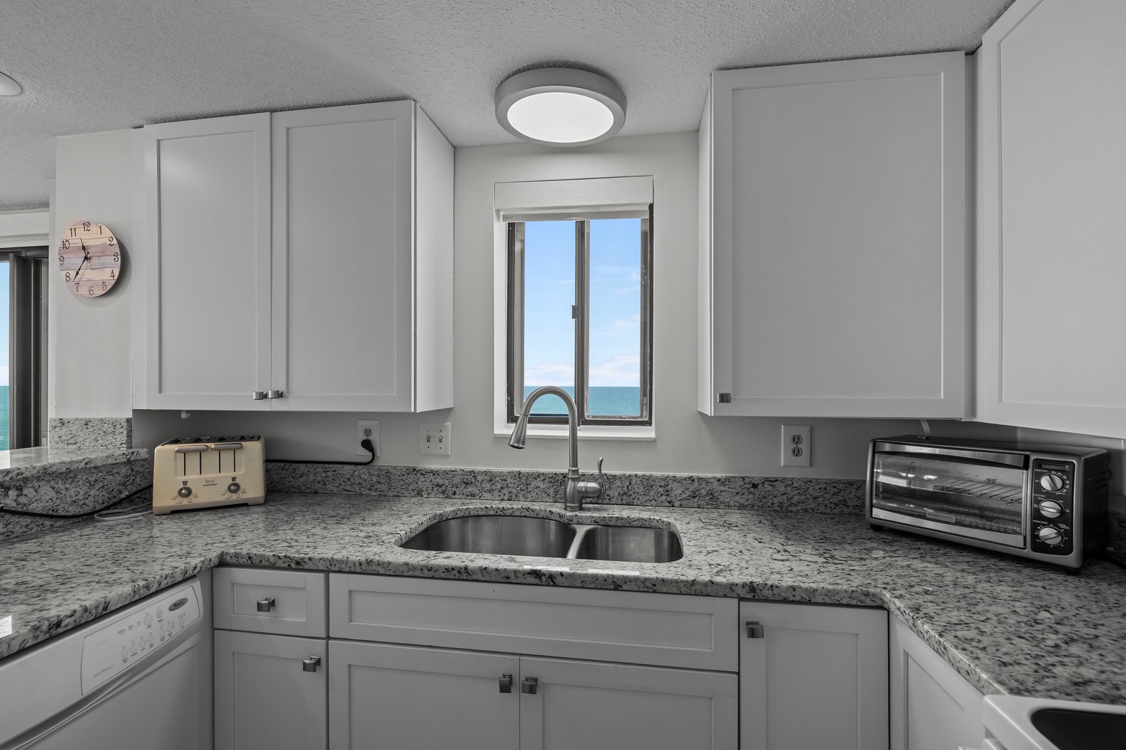 Your fully equipped kitchen features granite countertops and stunning ocean views through the window.