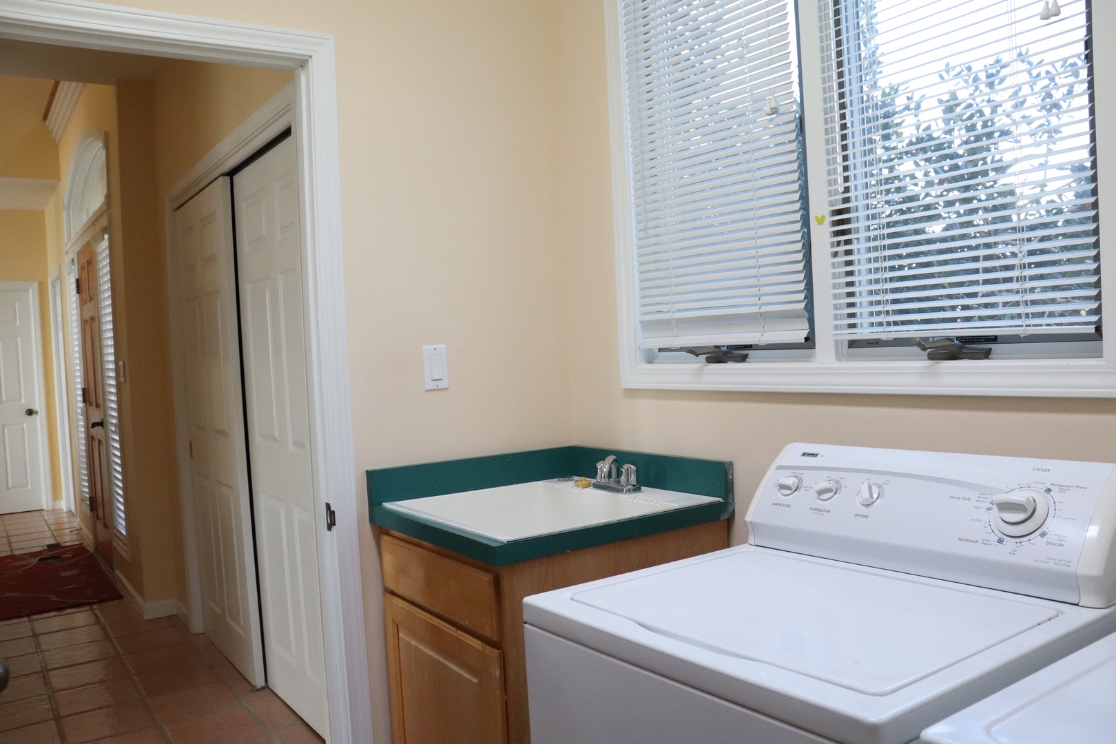 Your dedicated laundry space features a full-size washing machine and convenient countertop for folding clothes.