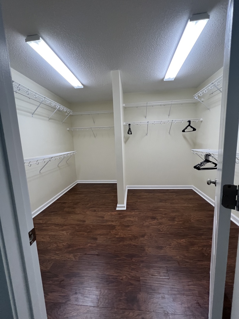 Your spacious walk-in closet offers plenty of room to organize your belongings with adjustable shelving and hanging space.