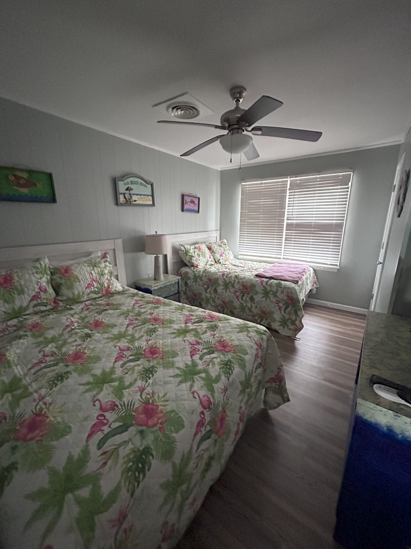 Rest peacefully in your tropical-themed twin bedroom with cheerful flamingo bedding and gentle ceiling fan keeping you cool.