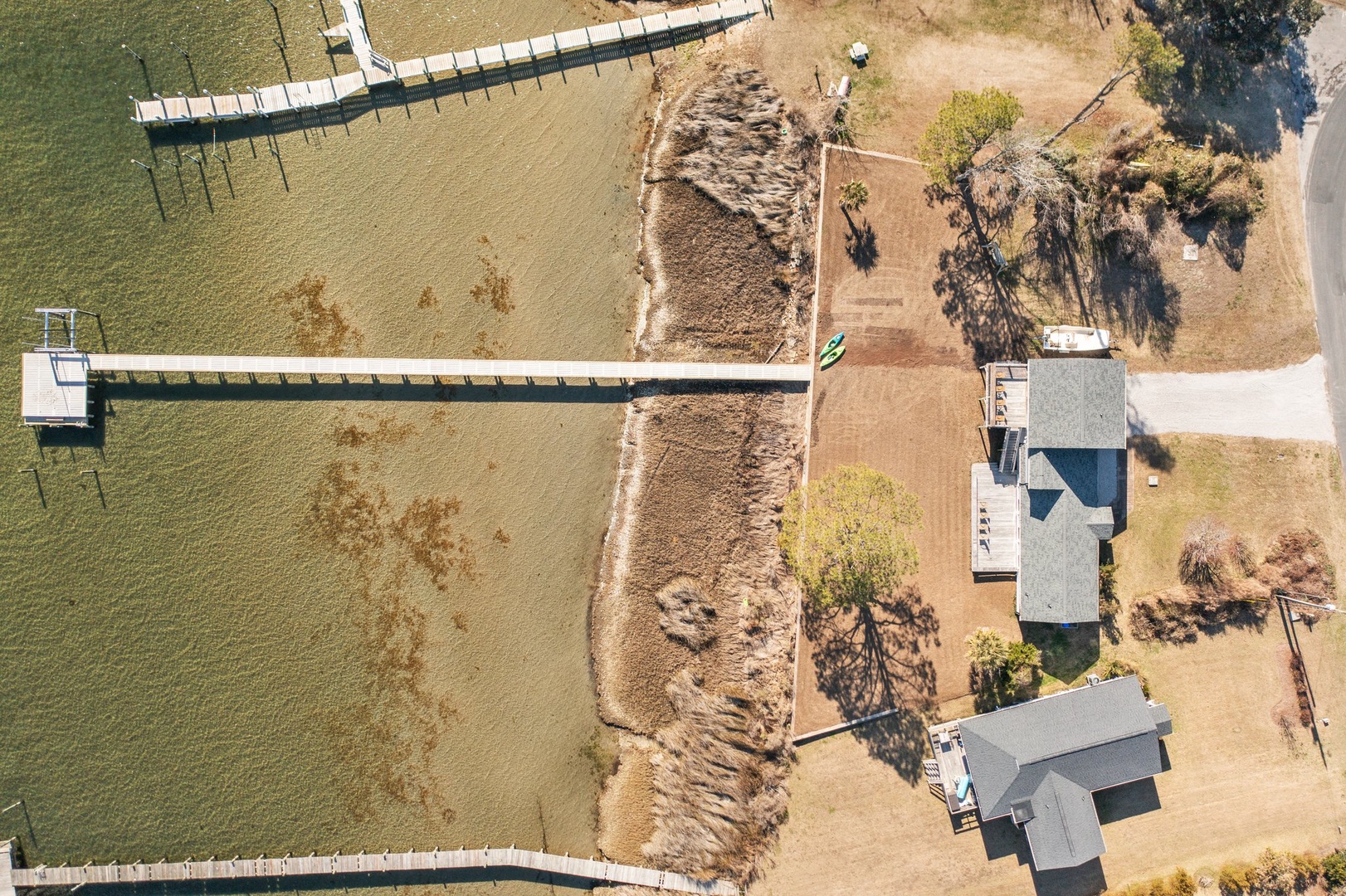 Aerial view of waterfront property featuring private dock access and peaceful lakeside setting with expansive natural surroundings.