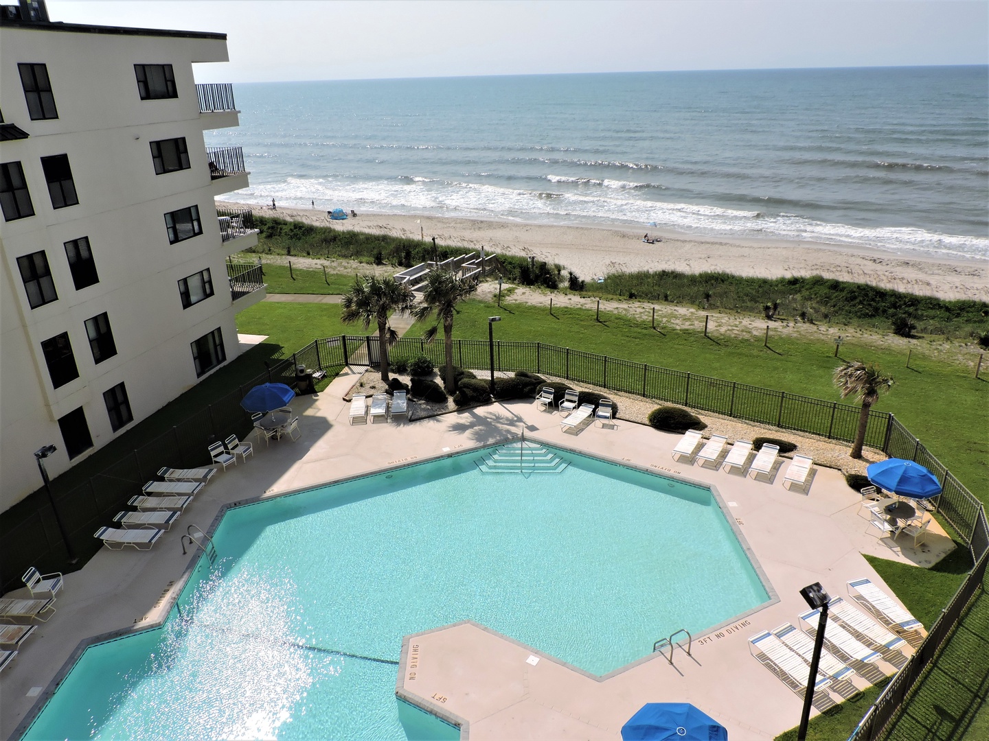 Wake up to this stunning oceanfront view from your balcony, where the sparkling pool meets endless beach and rolling waves.