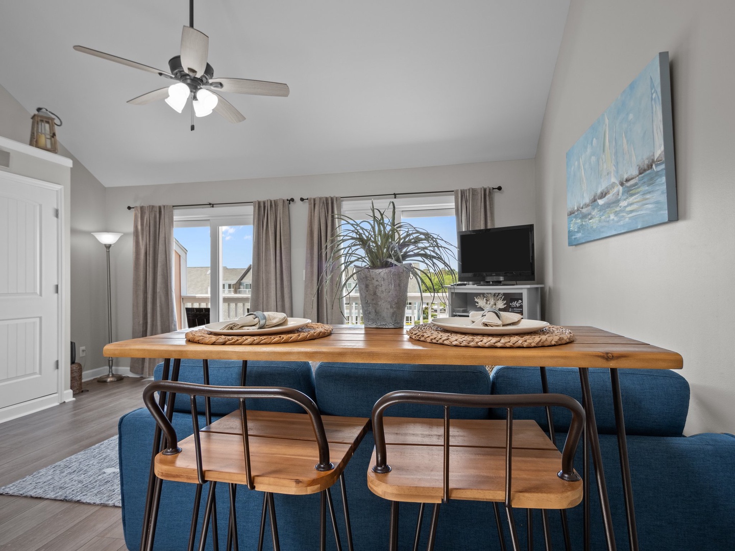Gather around your stylish dining table where warm wood meets modern design. Natural light floods through sliding doors creating the perfect spot for meals.