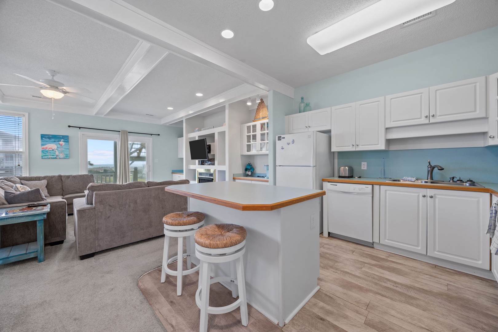 Your bright coastal retreat features a fully equipped kitchen island where you can prepare meals while enjoying ocean views and socializing.