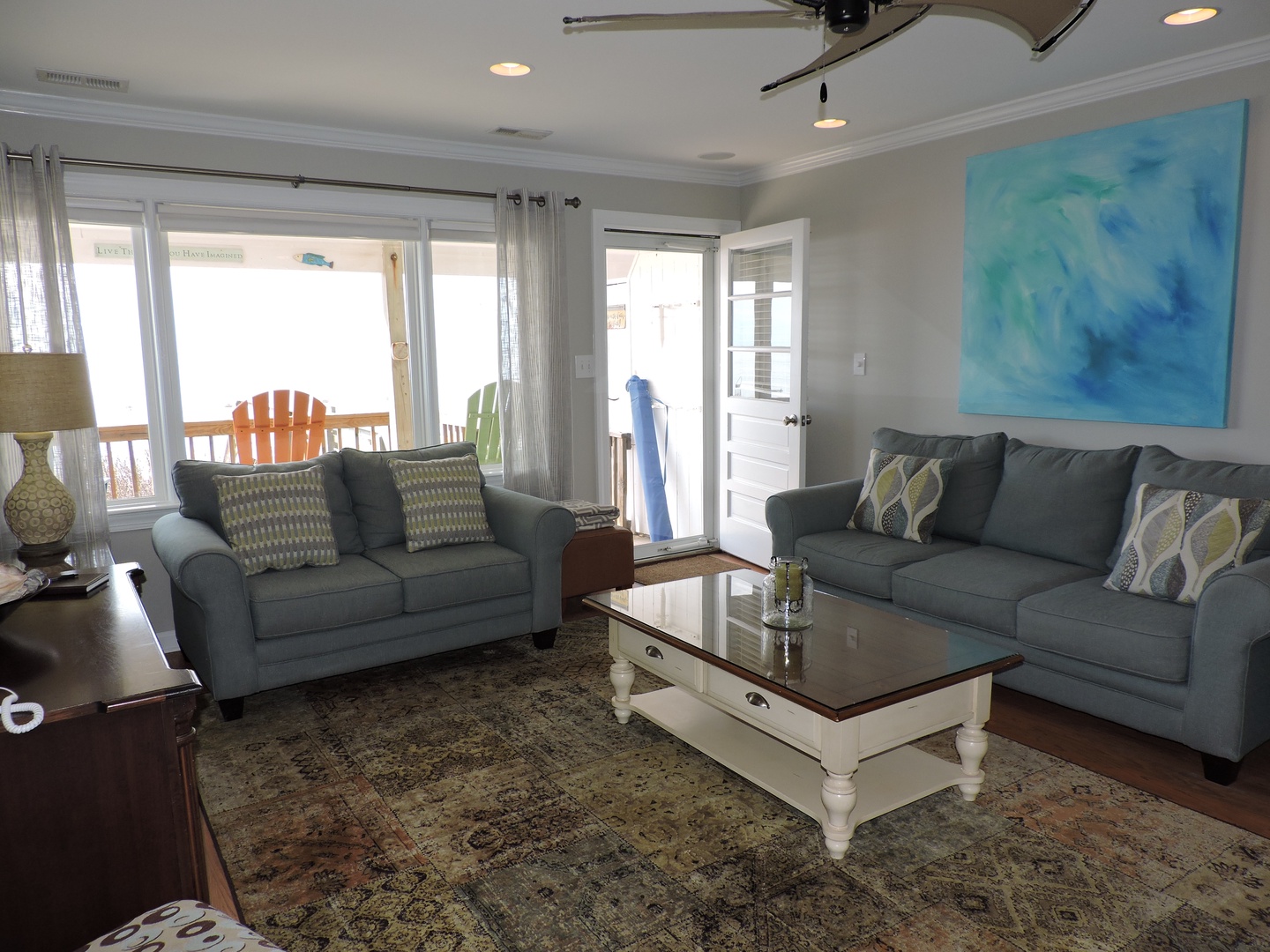 Unwind in your spacious living area with plush sofas and ocean-inspired art. Large windows fill the room with natural light while you relax.